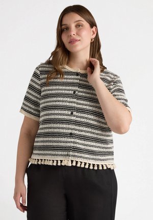 Top in maglia con righe orizzontali nere e crema, maniche corte, scollo tondo e bordo con pompon sul fondo. Chiusura a bottoni davanti.