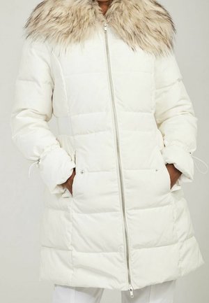 Witte pufferjas met een nepbont kraag, voorzien van een rits aan de voorkant, zijzakken en elastische manchetten. Glad textiel met een geplisseerd patroon.