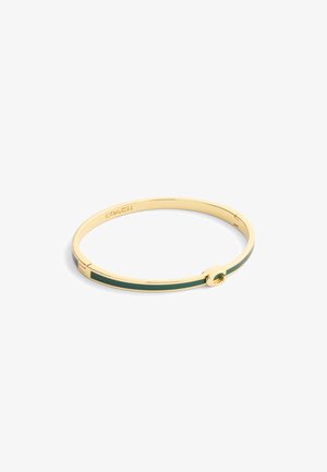 Guldfärgad banglearmband med en grön emaljrand, minimalistisk design och signaturlogo ingraverad. Cirkulärt accentdetalj är närvarande.