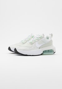 White and light green athletic sneakers with mesh and synthetic overlays, topped with a rubber sole and visible air cushioning in the heel.