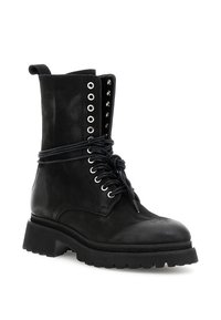 Zwarte leren militaire laars met dikke zool, metalen oogjes en veters die om de enkel zijn gewikkeld op een witte achtergrond.