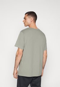 Nike Performance CREW SOLID - Sports T-shirts - dark stucco
