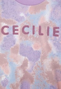 Felpa di cotone con un motivo tie-dye pastello in toni di rosa, viola e blu. La parola "CECILIE" è visibile in lettere testurizzate e soffici.