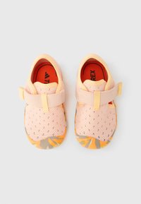 Ανοιχτό ροζ παπούτσια με δίχτυ, πορτοκαλί λεπτομέρειες, λουράκι με  βέλκρο και σόλα από καουτσούκ με σχέδιο. Ανοιχτή μύτη με διάτρητο πάνω μέρος για αναπνοή.