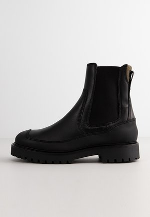 Schwarze Leder Chelsea-Stiefel mit elastischen Seitenteilen, abgerundeter Spitze und rutschfester Gummisohle. Mit einer Schlaufe für einfachen Einstieg.