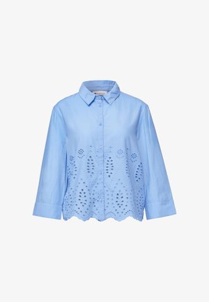 Jasnoniebieska bluzka z długim rękawem, z kołnierzykiem, z przodu zapinana na guziki oraz z ażurowym, kwiatowym wzorem na dolnej połowie i falowanym brzegiem.