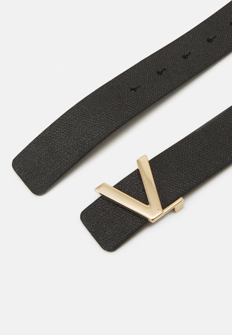 Schwarzes, strukturiertes Lederarmband mit einer goldenen, geometrischen V-förmigen Schnalle, die mehrere Einstelllöcher zur Größenanpassung bietet.