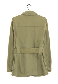 Giacca utility verde oliva con vita regolabile, polsini abbottonati e colletto ripiegato. Tessuto morbido con dettagli di cucitura discreti.