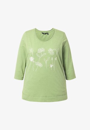 Hellgrünes langärmliges Hemd mit rundem Ausschnitt und weiß gezeichneten Blumenmustern über der Brust.