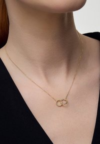 Złoty naszyjnik z dwiema splecionymi obręczami, jedna gładka, a druga skręcona. Delikatny łańcuszek, który leży tuż nad obojczykiem.