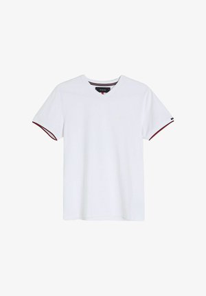 Biała bawełniana koszulka z dekoltem w serek, krótkimi rękawami oraz czerwonymi i czarnymi paskami na końcach rękawów. Luźny krój, minimalne oznakowanie.