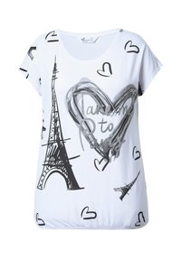 Camiseta blanca de manga corta con gráficos en negro de la Torre Eiffel y un corazón, con la frase "Llévame a París" en letras plateadas, textura de tela suave.