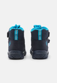Bottines bleu marine avec une doublure turquoise douce, tige en textile, bande auto-agrippante et semelle en caoutchouc texturée ; deux rayures bleu clair à l'arrière.