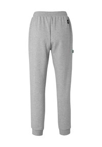 Grå bomulds sweatpants med elastisk talje, tapered manchetter og et lille grønt logo-tag på baglommen. Blød tekstur, enkelt design.