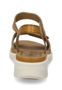 Brune lædersandaler med en polstret indersål og hvid gummisål, der har flere stropper for støtte og et åbent bagside-design.