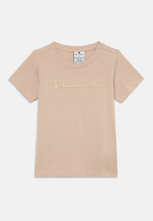 Camiseta de algodón de manga corta en color beige con cuello redondo y el logotipo bordado "Champion" en el pecho.