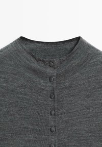Dark gray knit top featuring a round neckline and six covered buttons down the front. Soft texture with a smooth finish and no visible pattern.