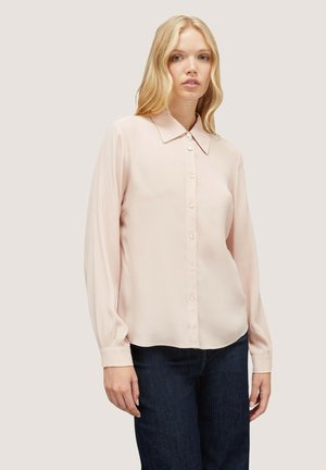 Blusa rosa a maniche lunghe con colletto a punta, chiusura frontale con bottoni e vestibilità leggermente ampia. Realizzata in un tessuto morbido con una leggera lucentezza.
