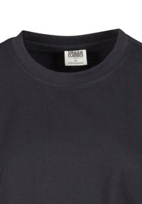 Černé tričko z organické bavlny s kulatým výstřihem a krátkými rukávy. Obsahuje vnitřní štítek ukazující velikost XS a zemi původu, Bangladéš.