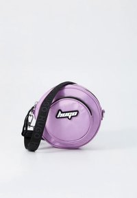 Okrągła fioletowa torebka na ramię wykonana z błyszczącego materiału, z czarnym paskiem z napisem „hugo” i wyraźnym logo na środku.