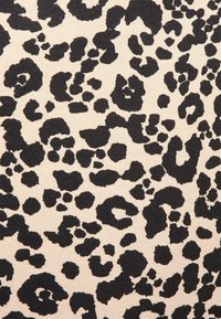 Tela de estampado de leopardo con fondo beige, que presenta manchas negras irregulares de diferentes tamaños y formas, textura densa y acabado suave.