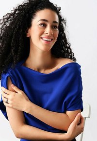 Blaues Off-Shoulder-Kleid aus glattem Stoff; lockere Passform; kurze Ärmel; mit sanften Drapierungen und einem lässigen Ausschnitt.