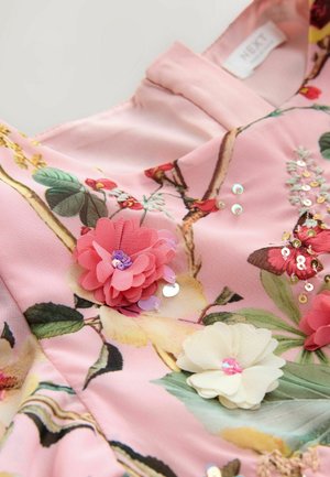 Roosa lilleline kleit, millel on kangast lilled roosa ja kreemi tooni, sädelused ja botaanilised mustrid roheliste lehtede ning oksade kujunditega.