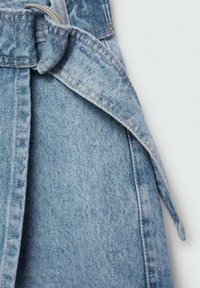 Svetlo modra denim tkanina z zloženim pasom in zanko za pas. Mehka tekstura z nežnim bledenjem in vidnimi detajli šivanja.