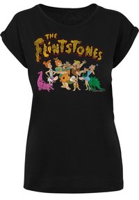 Svart t-skjorte med rullet ermer som har et fargerikt grafisk motiv av "The Flintstones"-figurene i en leken posisjon, med fet tekst over.
