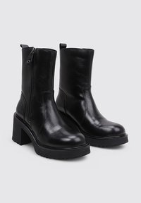 Black leather ankle boots featuring a square toe, side zipper, chunky heel, and textured rubber sole. Smooth finish with minimal accents.