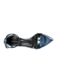 Tacco a punta con una finitura blu metallico, dotato di una fascia larga sul collo del piede e di un cinturino alla caviglia con dettaglio a fibbia circolare.