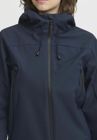 Dunkelblaue Jacke mit Kapuze, vorderem Reißverschluss und doppelten Seitentaschen mit eleganten schwarzen Akzenten und verstellbaren Kordeln. Weicher, strukturierter Stoff.