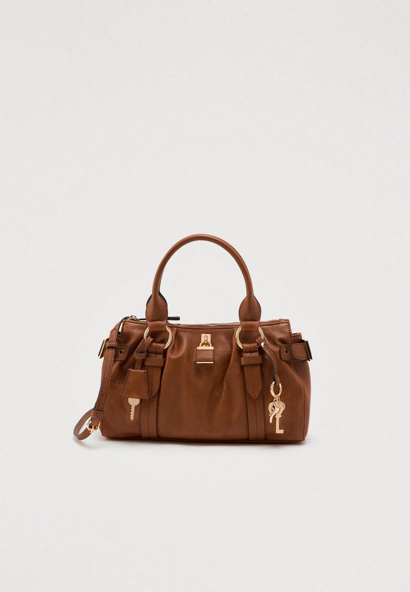Brązowa skórzana torba na ramię o wyraźnym kształcie, z podwójnymi uchwytami, złotymi akcentami oraz dekoracyjnymi zawieszkami w kształcie klucza i logo.