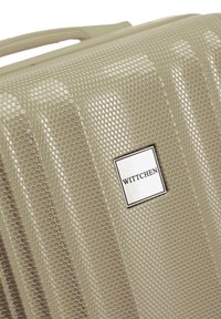 Valigia rigida color beige con un motivo esagonale testurizzato, dotata di una placca con il logo WITTCHEN e un manico ergonomico elegante.
