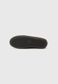 Bruine suede schoenzool met een gestructureerde zwarte rubberen buitenzool, voorzien van een geperst merklogo en patroon. Gecentreerd, rond te ontwerp.