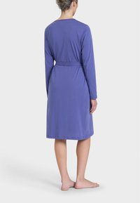 Roba viola a maniche lunghe con cintura, realizzata in un tessuto liscio e leggero. Presenta un design semplice e lunghezza fino al polpaccio.