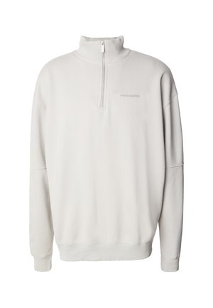 Krémovo biely sveter s polovičným zipsom, vysokým golierom, rebrovanými manžetami a lemom, s jemným logom "PEGADOR" na ľavej strane hrude.