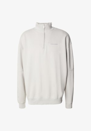 Krémovo biely sveter s polovičným zipsom, vysokým golierom, rebrovanými manžetami a lemom, s jemným logom "PEGADOR" na ľavej strane hrude.