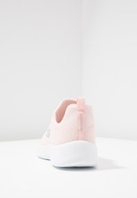 Jasnoróżowy tekstylny sneaker z siatkowym wierzchem, białą gumową podeszwą i tylną pętlą do ściągania. Posiada subtelne oznakowanie po bokach.