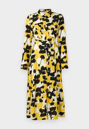 Vestido de manga larga en un patrón floral de color amarillo, blanco y negro. Presenta un cierre frontal de botones, cuello, bolsillos de pecho dobles y un cinturón en la cintura.