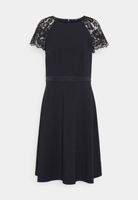 Vestido preto com mangas curtas de renda, decote redondo e corpete justo. Apresenta um cinto de cetim na cintura e uma saia rodada.
