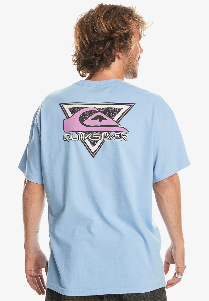 Camiseta de algodón azul claro con un gran diseño gráfico en rosa y negro en la parte posterior, de corte relajado y con mangas cortas.
