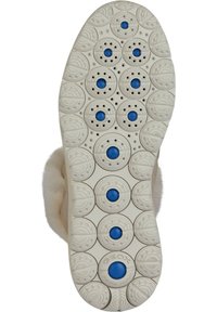 Suela blanca con patrones circulares y puntos de acento azules, con perforaciones para una mejor transpirabilidad. El caucho texturizado proporciona agarre.