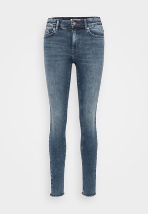 Skinny jeans in medium wash denim, featuring a classic five-pocket design, subtle whiskering, and frayed hems for a casual look.
