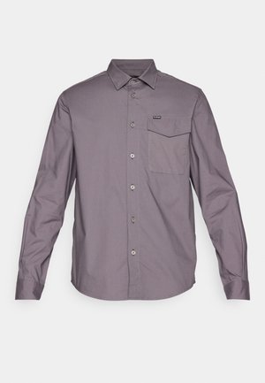 Chemise à manches longues en tissu violet-gris. Dotée d'une poche poitrine, d'un col et de boutons en métal argenté. Texture lisse.
