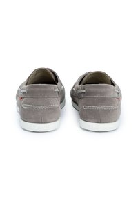 Graue Wildleder-Slipper mit weißer Gummisohle, die kontrastierende Nähte, Metallösen und ein kleines rotes Akzentdetail aufweisen.