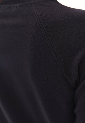 Zwarte gebreide kleding met een gladde, gestructureerde oppervlakte en zichtbare stiksels langs de schoudernaad. Lichtgewicht en aansluitend ontwerp.