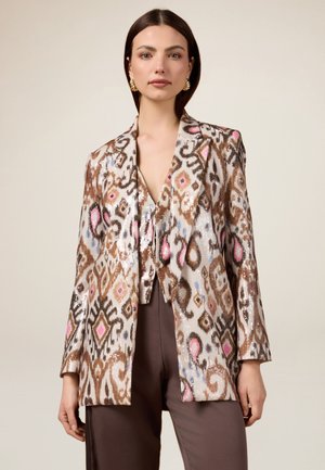 Blazer en sequins marron, crème et rose avec un motif abstrait ; design structuré, revers larges et coupe décontractée, associé à un top à bretelles.