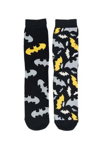 Calzini neri e grigi con motivo a pipistrello. Un calzino presenta pipistrelli gialli, mentre l'altro ha un motivo di pipistrelli sparsi in grigio e bianco.