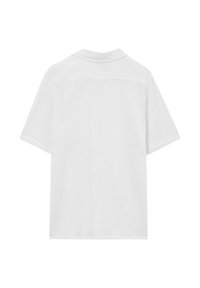 Camicia bianca a maniche corte con colletto vista da dietro su uno sfondo bianco.